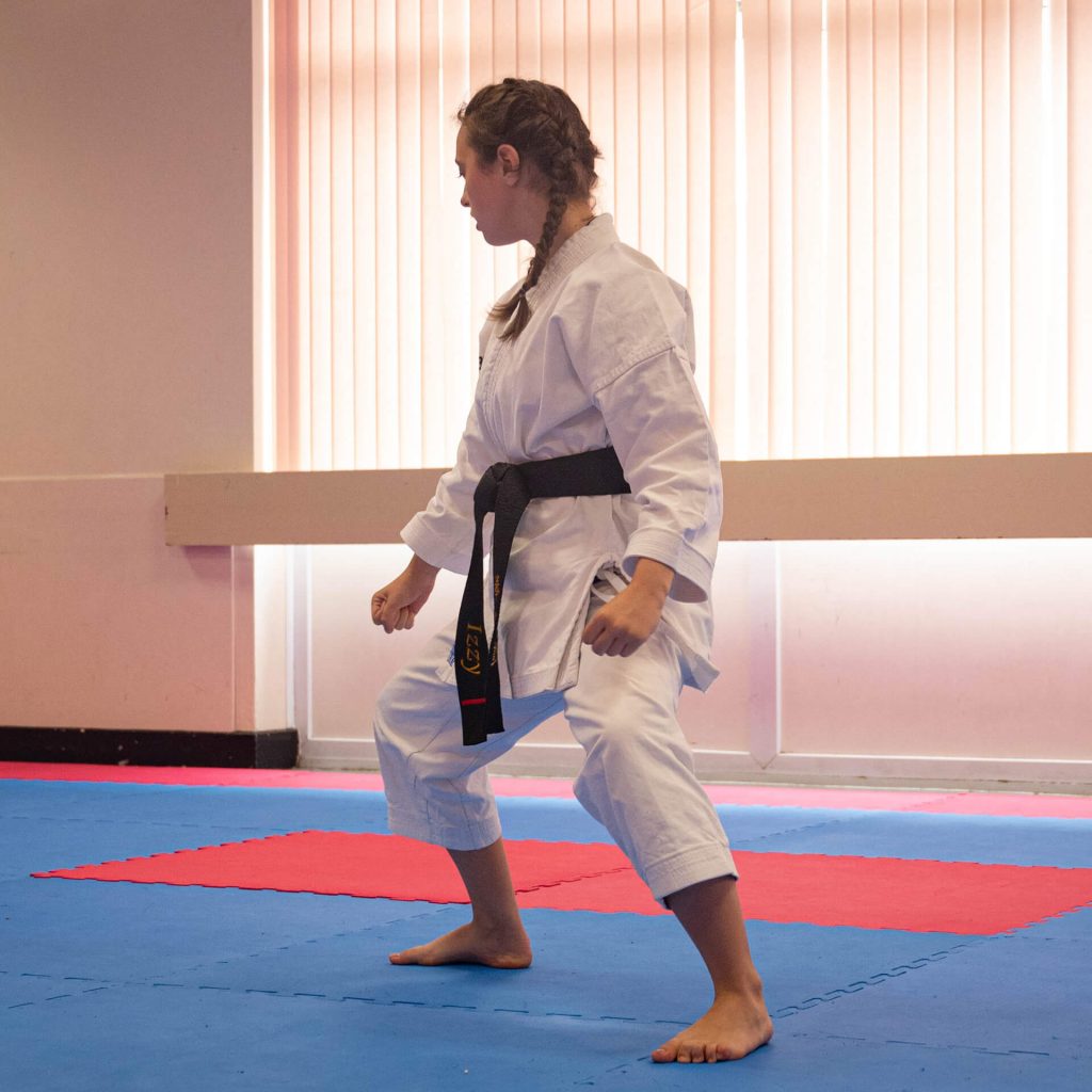 Young female karate student performing kata